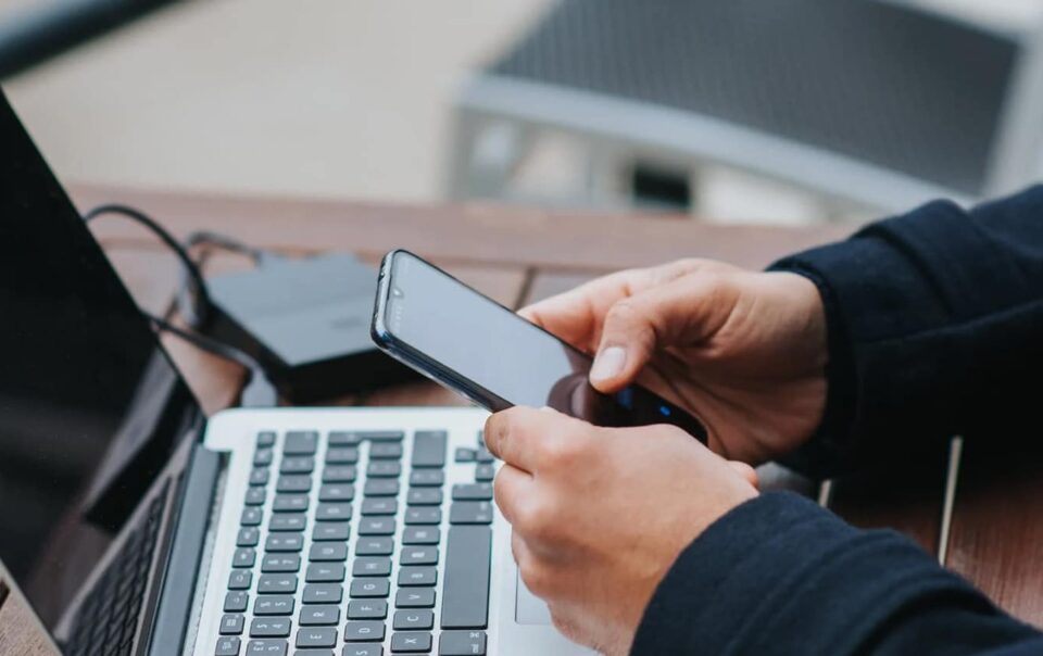 Homem com um celular e um computador Foto de Anete Lusina no Pexels