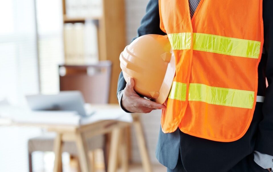 unrecognizable male construction industry executive posing in safety vest with hardhat 2 1 1