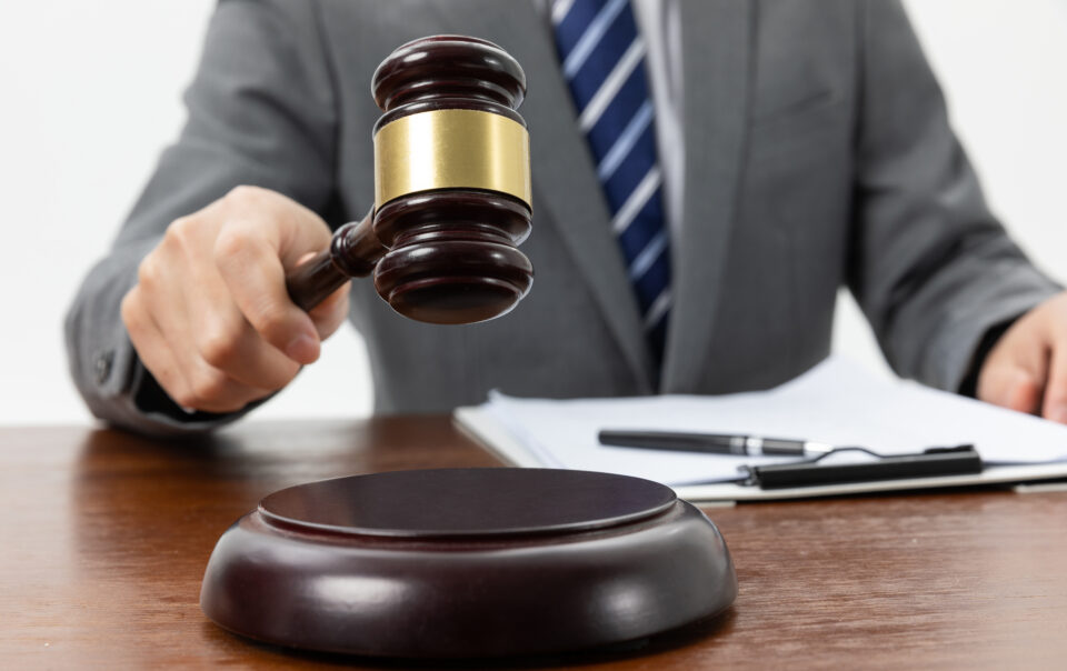 closeup shot person holding gavel tabl