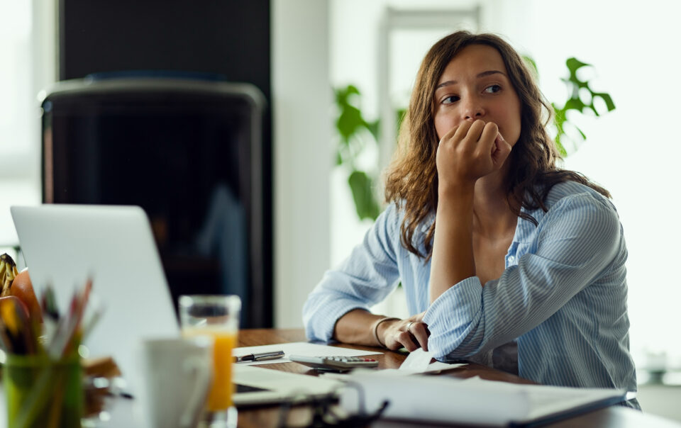 young worried woman thinking something while calculating her home budget