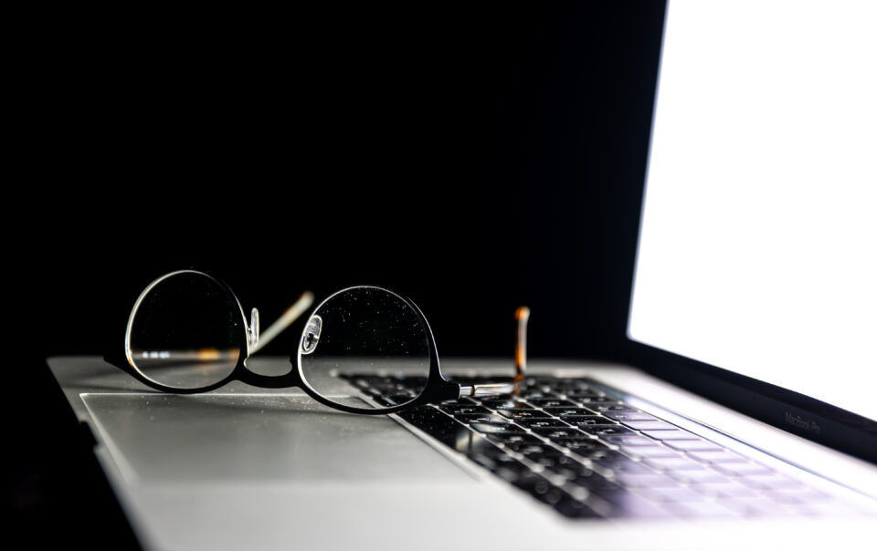 close up glasses laptop dark