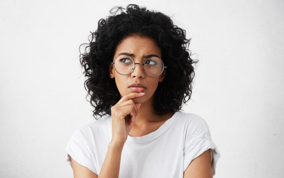 isolated portrait stylish young mixed race woman with dark shaggy hair touching her chin