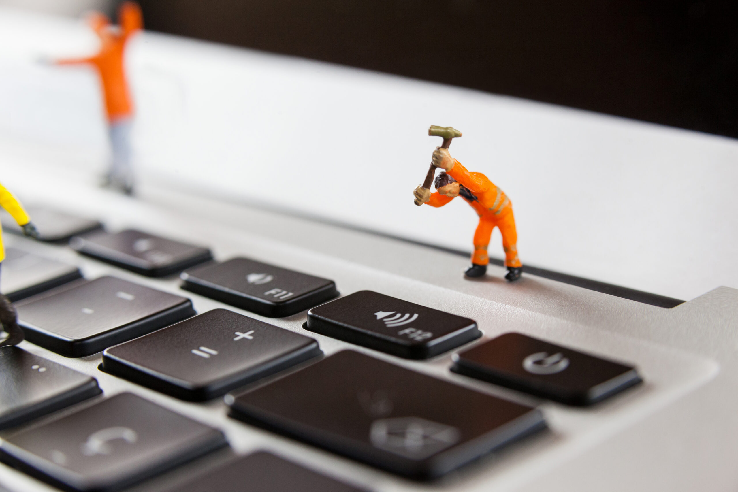 miniature workmen repairing laptop keyboard scaled