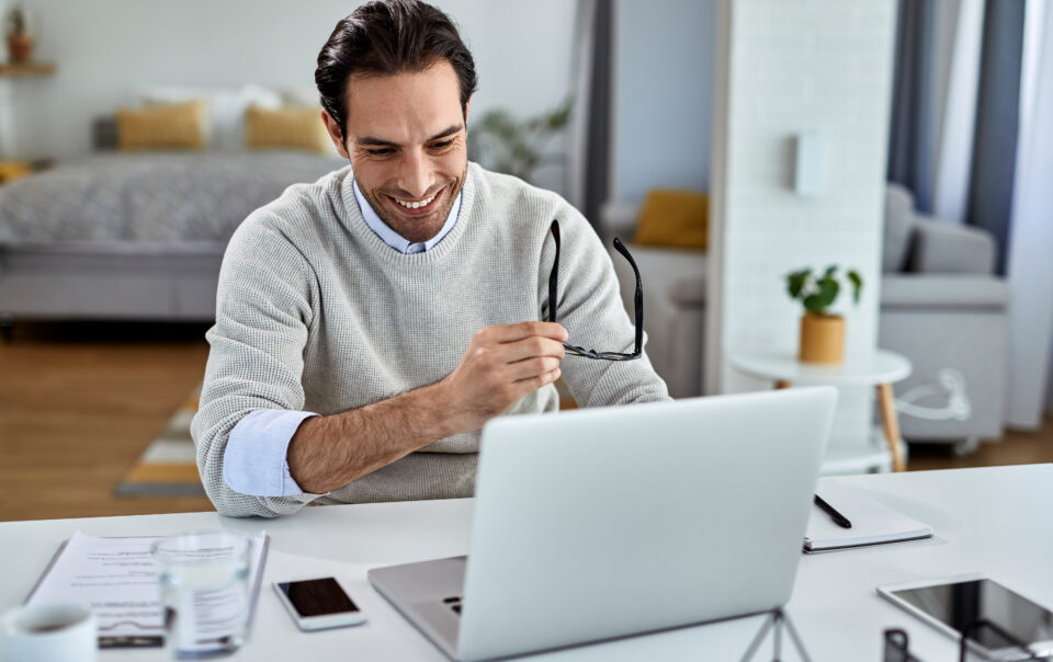 feliz empresario usando computador enquanto trabalhava em casa